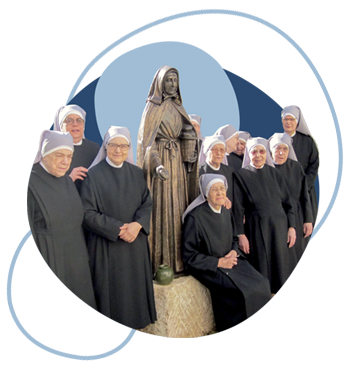 Grupo de Irmãzinhas dos Pobres junto à estátua de Santa Joana Jugan